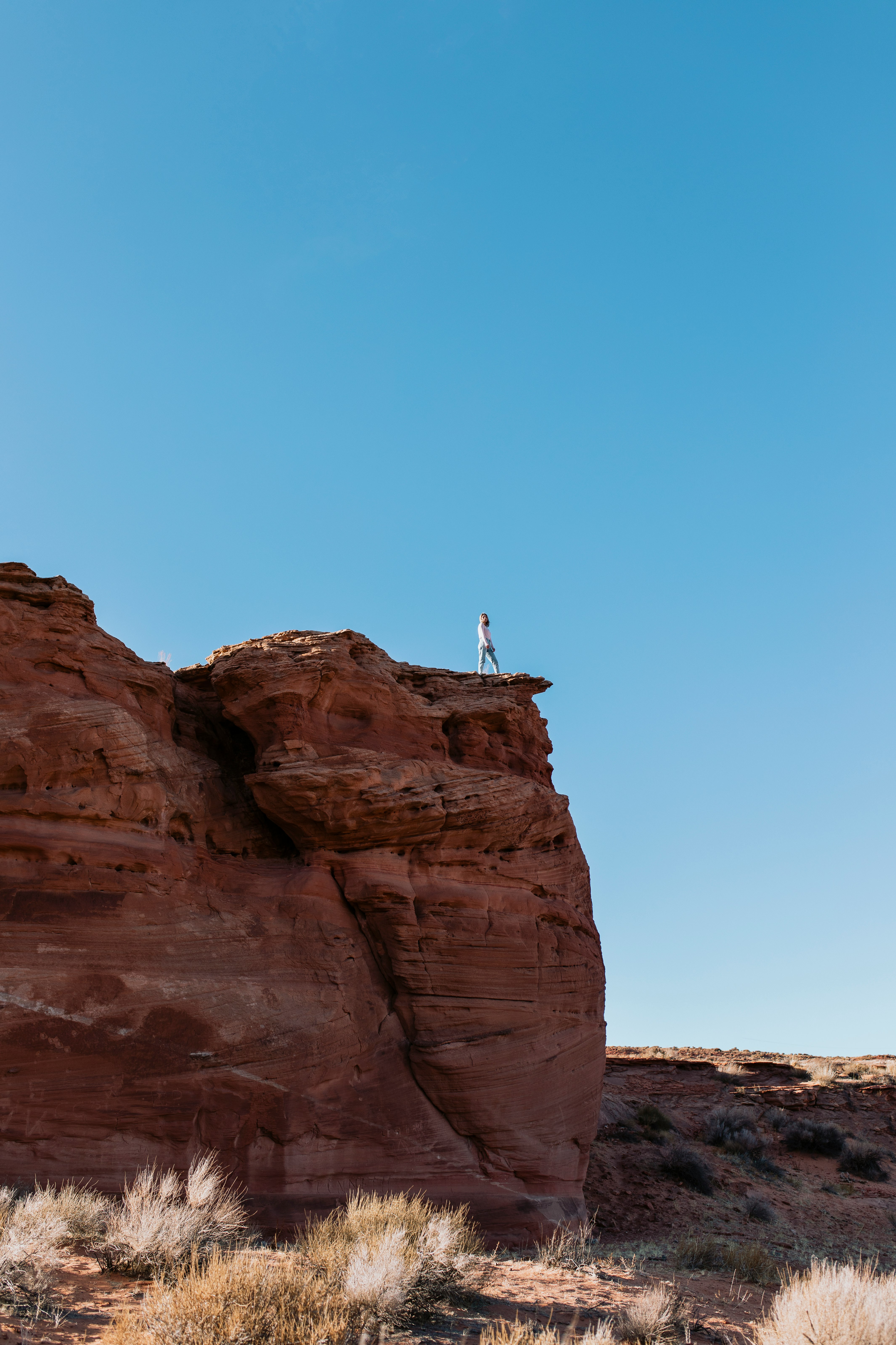 person standing on brown rock formation during daytime